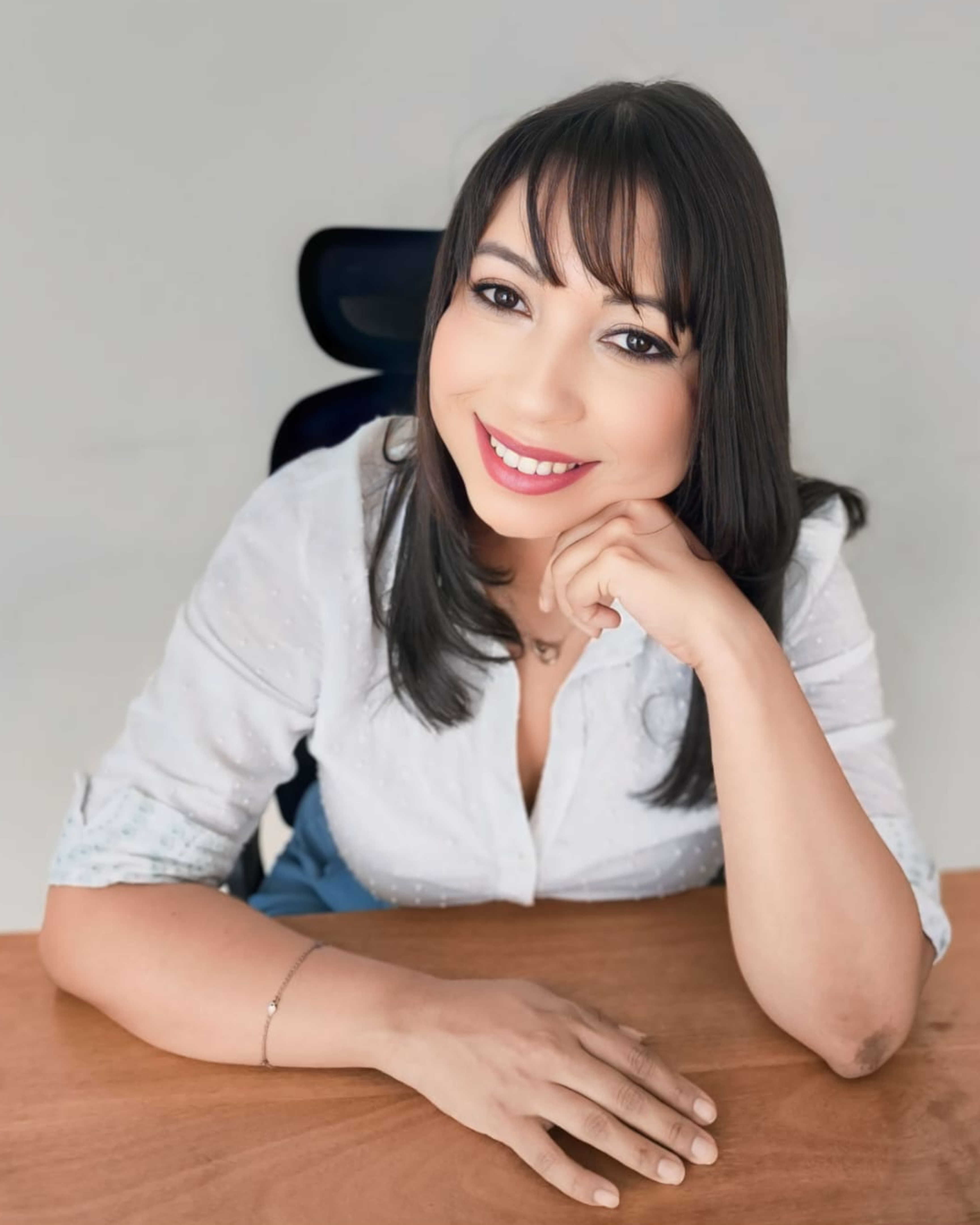 Psicóloga Manu em apoiada em mesa de atendimento